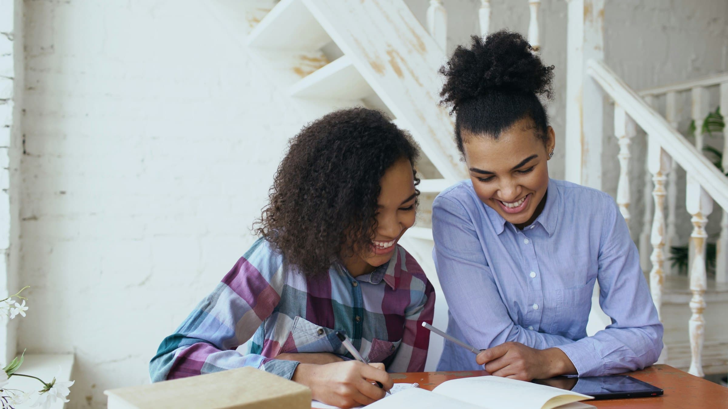 Coach and student working together at a table, smiling